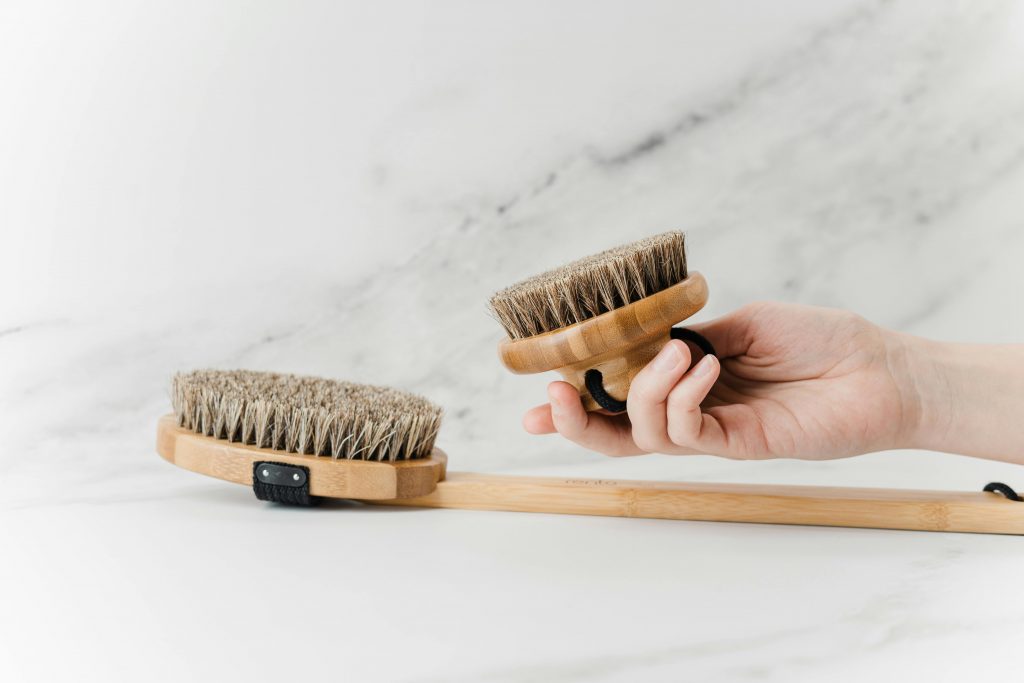 Empleado de empresa de limpieza muestra utensilios de limpieza hecho de materiales sostenibles.
